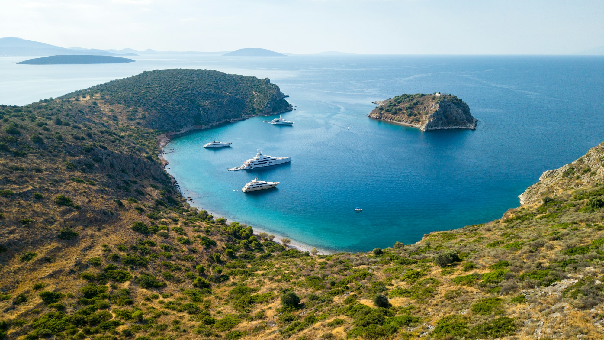 Superyachts anchored in a turquoise Mediterranean cove